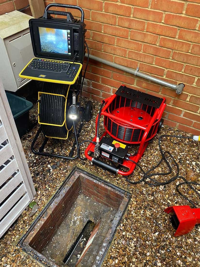CCTV drain camera and mechanical drain cleaner set up beside a Bracknell manhole